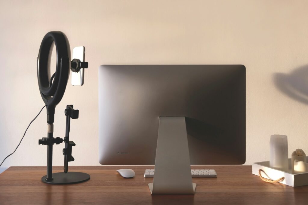 Ring lamp on blogger's desktop in home interior. Technical equipment for online promotion